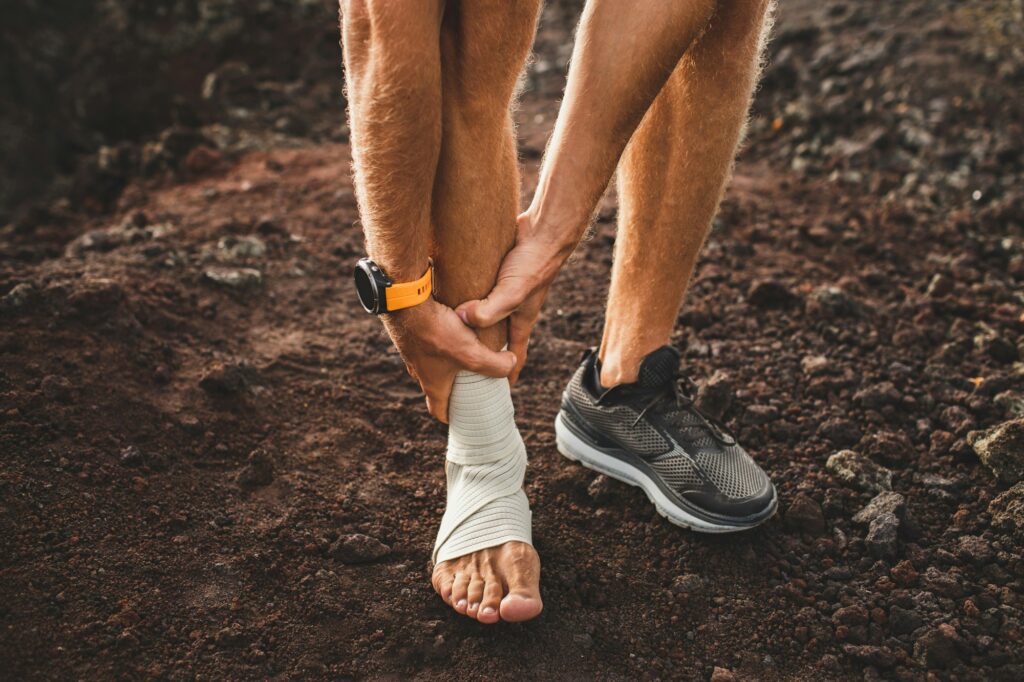 Male runner holding injured leg close-up and suffering with pain. Leg injury. Sprain ligament