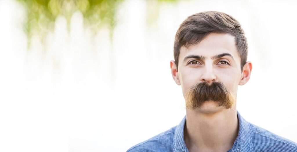 Young man with fake mustaches.